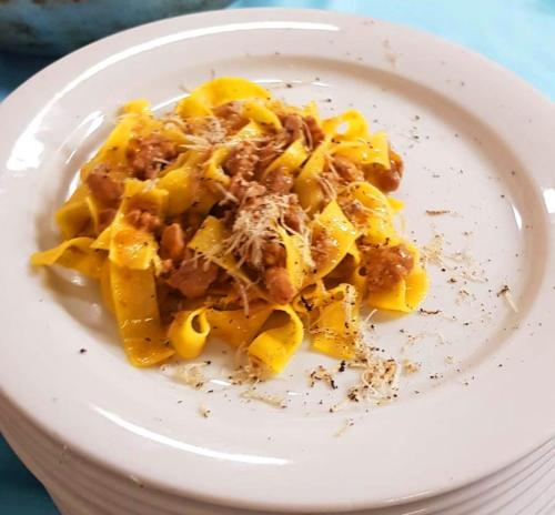 a white plate of pasta with meat and cheese at Hotel Ca' Bianca in Riccione