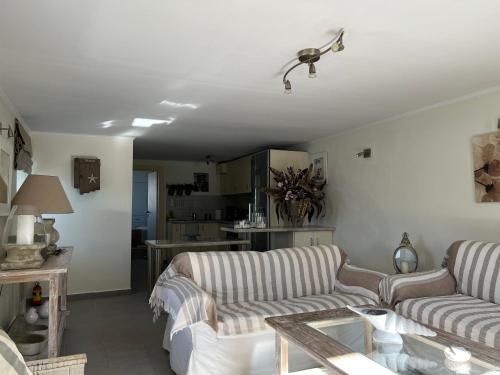 ein Wohnzimmer mit 2 Sofas und einem Tisch in der Unterkunft Kasteli Suite in Poros