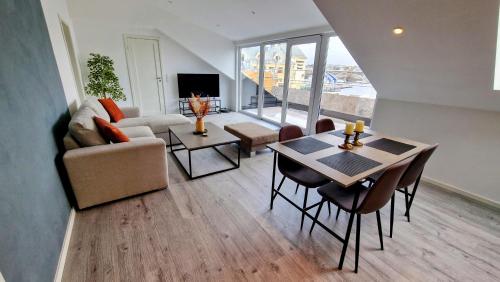 a living room with a table and a couch at Lovely 2-bedroom loft with panoramic view. in Kristiansund