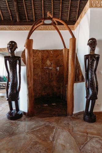 two statues sitting on the floor in a room at The Island - Pongwe Lodge in Pongwe