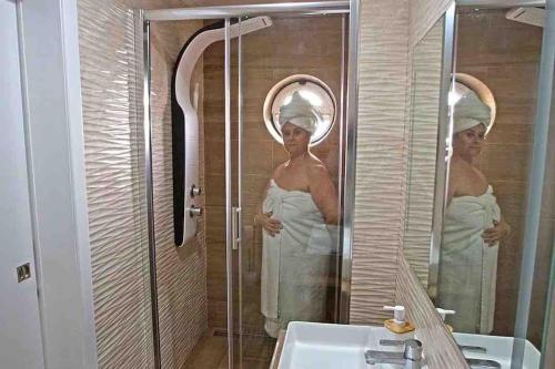 a woman in a mirror in a bathroom at WATERS HOUSE STUDIO in Peniche