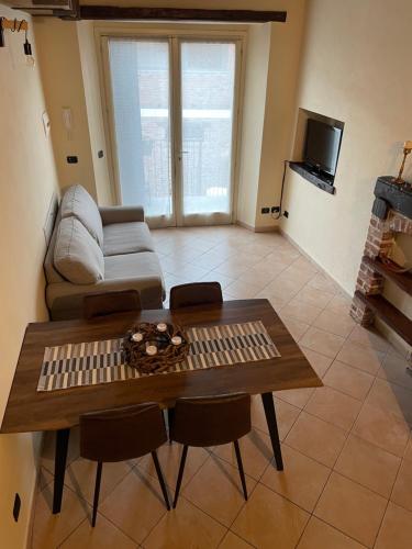 a living room with a table and a couch at Langhetruffle apartment in La Morra