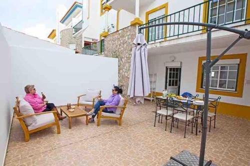 two people sitting in chairs on a patio at WATERS HOUSE STUDIO in Peniche