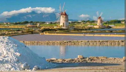 two windmills in a field with snow on the ground at Central Apartment Macari Cala Azzurra Residence in Macari