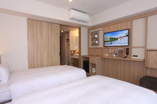 a hotel room with two beds and a flat screen tv at Sapporo Washington Hotel Plaza in Sapporo