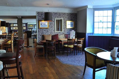 a dining room with tables and chairs in a restaurant at Red Lion Hotel by Greene King Inns in Fareham