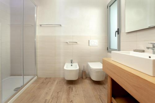ein Bad mit einem WC, einem Waschbecken und einer Dusche in der Unterkunft Capotesta Luxury Rooms in Santa Teresa Gallura
