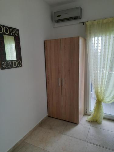 a room with a wooden cabinet and a window at Dimos Sunny & Luxury Central House !!! in Perea