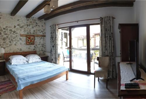 a bedroom with a bed and a sliding glass door at Pensiunea Casa Dacilor in Podeni