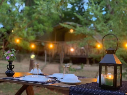 una mesa de madera con una linterna encima en Camp Leopard - Yala Safari Glamping, en Yala