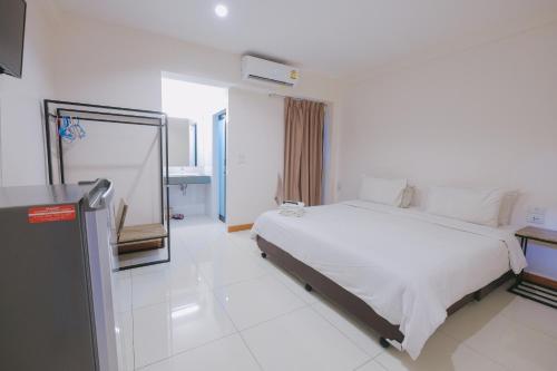 a white bedroom with a bed and a mirror at Don Muang Hotel in Bangkok