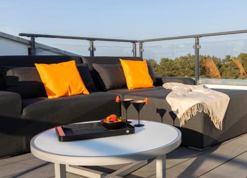 a living room with a couch and a table at Penthouse am Südstrand - Kamin, Dachterrasse mit Meerblick und Gasgrill, Luxus-Design-Apartment, 2 Minuten zum Strand, Klimaanlage in Binz