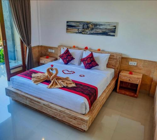 a bedroom with a large bed with towels on it at Pulu Sari Suite Ubud in Ubud