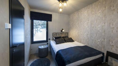 a small bedroom with a bed and a window at Santalahti Resort Cottages & Villas in Kotka