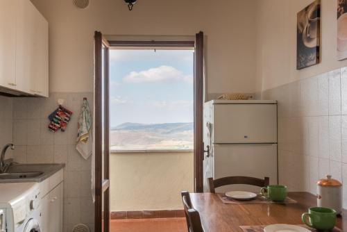 モンテプルチャーノにあるLa Zia Marisaのキッチン(テーブル、冷蔵庫付)、窓が備わります。