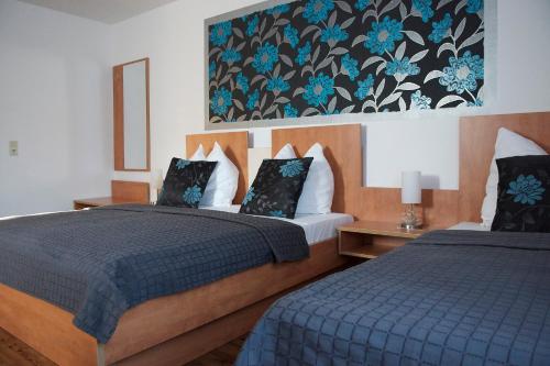 a hotel room with two beds and a painting on the wall at Hotel Vier Löwen in Traben-Trarbach