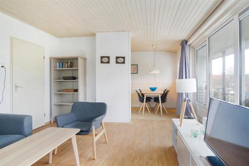 uma sala de estar com uma televisão e uma mesa e cadeiras em Hello Zeeland - Appartement Beatrixstraat 27 em Domburg