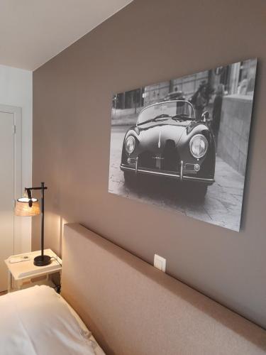 a picture of a car on a wall above a bed at B&B De Floreffe in Overpelt