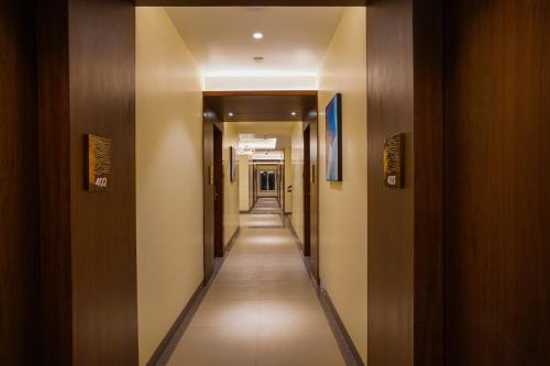 a corridor of a building with a long hallway at Hotel El Magnifico in Surat