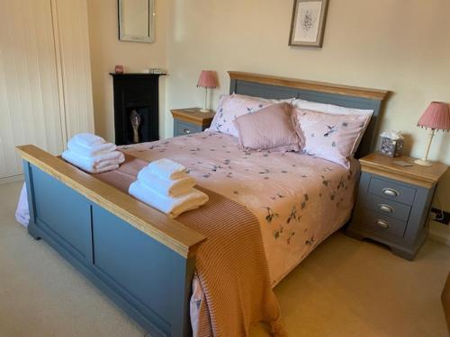 ein Schlafzimmer mit einem großen Bett mit zwei Nachttischen in der Unterkunft Charming Cottage, Great Rissington, Cotswolds in Great Rissington