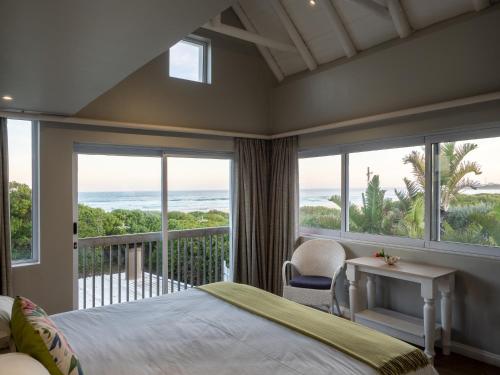 1 dormitorio con cama y vistas al océano en Beach Break Guest Houses and Villas en Cape Saint Francis