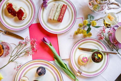 a table with plates of food and flowers on it at Great Fosters - Near Windsor in Egham