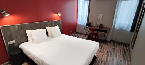a bedroom with a large bed with a red wall at Logis Hotel Yseria - Historical Center in Agde