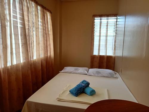 Una cama pequeña con un par de zapatos azules. en Laguno Bed And Breakfast Hostel en Moalboal