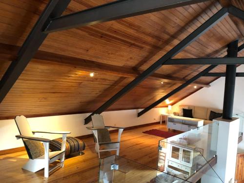an attic room with wooden ceilings and a table and chairs at Quinta Dos Anjos in Santarém