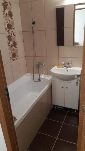 a bathroom with a bath tub and a sink at Apartament Georgian in Băile Tuşnad