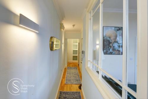 a hallway with white walls and a stairway with a picture on the wall at Leamington Spa Warwick Place Apartments in Leamington Spa
