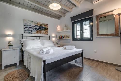 a bedroom with a large bed with two towels on it at Barbati Luxury House by Corfuescapes in Barbati