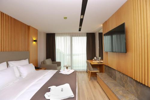 Habitación de hotel con cama y TV de pantalla plana. en Pikola Otel, en Ordu