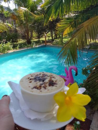 a cup of coffee next to a swimming pool at La Perla Bentota in Bentota
