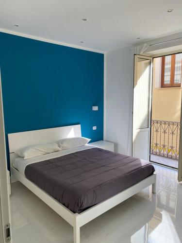 ein Schlafzimmer mit einer blauen Wand und einem Bett in der Unterkunft Vittorio Emanuele Suite Palermo in Palermo