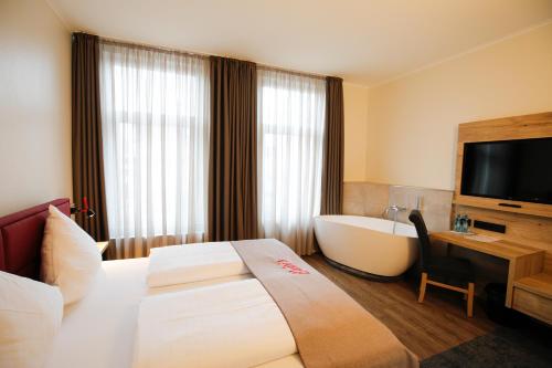 a hotel room with a bed and a bath tub at Hotel Restaurant Zur Linde in Westerstede