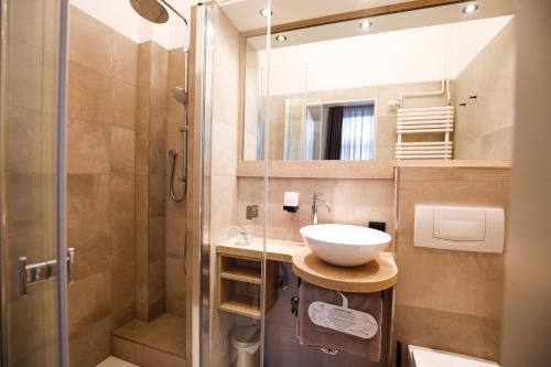 a bathroom with a sink and a shower at Hotel Restaurant Zur Linde in Westerstede