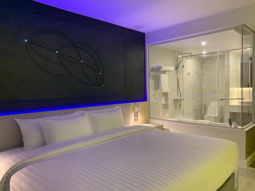 
a bedroom with a large bed and a large mirror at Pattaya Discovery Beach Hotel - SHA Extra Plus in Pattaya
