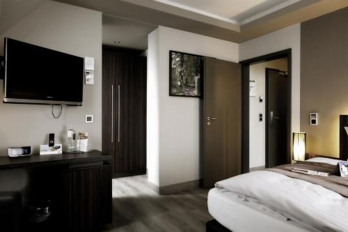 a bedroom with a bed and a flat screen tv at Villa Silva - Oberhof in Oberhof