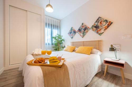 Un dormitorio con una cama con una bandeja de fruta. en City Centre Pool & Parking, en Málaga