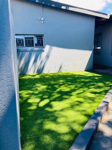 a building with a grassy yard next to a building at President Guest Lodge in Louis Trichardt