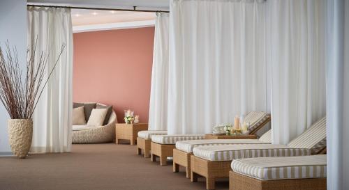 a living room with chairs and a couch and curtains at Fonteverde Lifestyle & Thermal Retreat - The Leading Hotels of the World in San Casciano dei Bagni