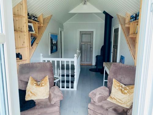 een woonkamer met 2 stoelen en een trap bij Lofoten Villa in Reine