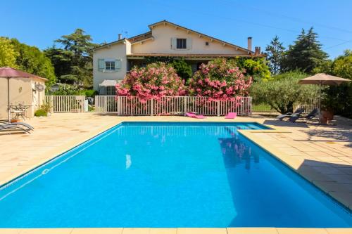 a villa with a swimming pool in front of a house at Mas Saint-Ange in Lunel