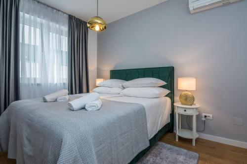 1 dormitorio con 2 camas con sábanas blancas y ventana en Exclusive Apartman AnaMarino, en Zadar