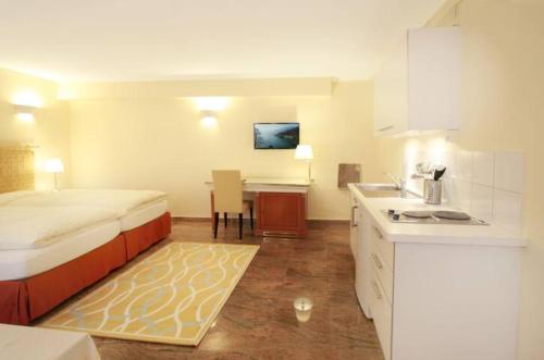 a small bedroom with a bed and a kitchen at Depandance Garni Golf in Ascona