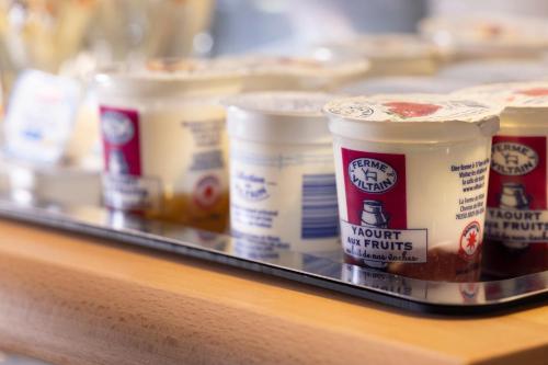 a tray with severaloops of yogurt in cups on a counter at Hôtel Hélios Opéra in Paris