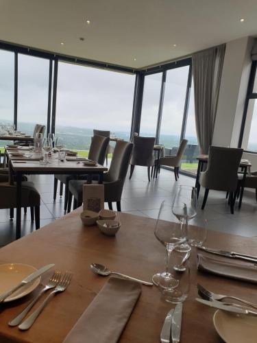 a dining room with tables and chairs and windows at The Northcliff Boutique Hotel in Johannesburg
