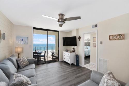 a living room with a couch and a tv at Sunswept 607 condo in Orange Beach