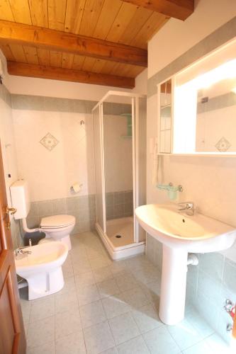 un bagno con due lavandini, un water e una doccia di Residence Aquila - Mono Corno Bussola a Brusson